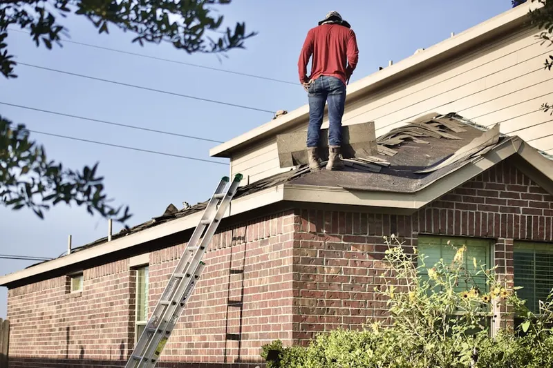 Professional roofer working on a residential roof in Monfort Heights